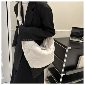 Detail of quilted crossbody bag with knot shoulder strap on professional outfit