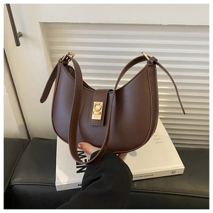 Détail d'un sac hobo en cuir marron avec boucle dorée vintage et forme demi-lune élégante