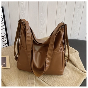 Detail view of large brown PU leather tote bag with silver hardware and side pocket