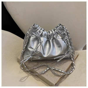Detail der silbernen Metallic-Beuteltasche mit Schleife und Kettenriemen