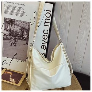 Close-up of beige faux leather tote bag with smooth matte finish and side pockets