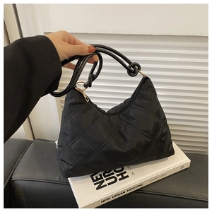 Close-up of black quilted nylon hobo bag with knot detail and gold metal hardware