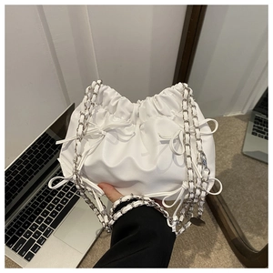 Detailansicht der weißen Plissee-Eimertasche mit Schleife und Lederkettenriemen