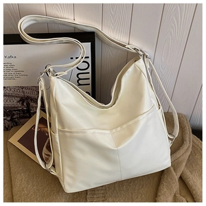 Detail of cream white tote bag featuring V-shaped stitching and soft faux leather texture