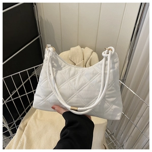 Detail of white quilted crossbody bag featuring dual rope straps and gold hardware adjustment