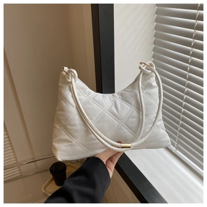 Detail view of white quilted hobo bag with stitched rhombic patterns and gold ring accents