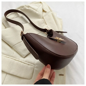 Détail du sac de selle vintage marron foncé avec son fermoir en métal doré brillant