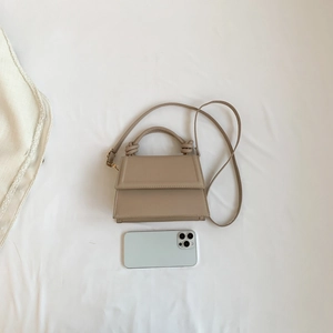 Sac à main beige minimaliste à anse nouée et bandoulière, présenté avec smartphone pour taille