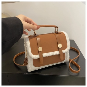 Detail of vintage brown leather handbag with white faux shearling trim and gold hardware
