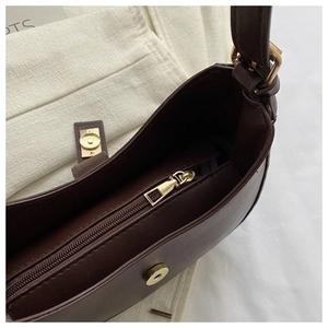 Vue détaillée du sac demi-lune en cuir PU chocolat avec fermeture éclair et finitions dorées