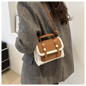 Detail of vintage crossbody bag with brown leather and white faux fur trim on model