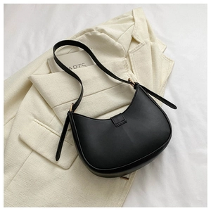 Détail du sac sous le bras noir minimaliste avec boucle en métal doré et sangle réglable