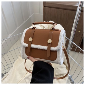 Detail of vintage crossbody bag with faux shearling trim and gold buckles in a metal basket