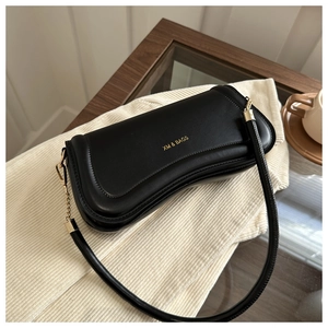 Detailed view of black synthetic leather shoulder bag with golden XM & BAGS logo