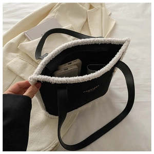 Close-up of black suede tote bag with white faux fur trim and spacious inner compartment
