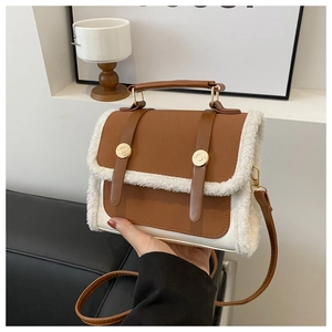 Detailed close-up of brown leather crossbody bag with white fleece trim and gold hardware