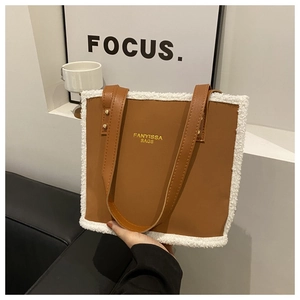 Detailed shot of brown PU leather tote bag with white faux shearling trim and shoulder straps