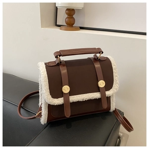 Detail of retro coffee crossbody bag featuring soft white faux shearling trim and gold buckles