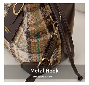 Detailed shot of golden metal hooks and textured tweed fabric on a retro bucket bag
