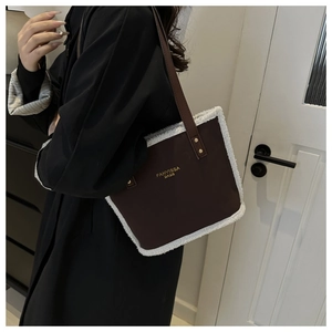Close-up of brown faux leather tote bag with white fleece trim and gold logo detail