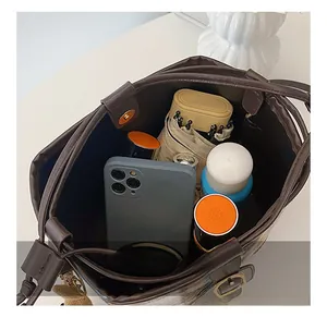 Deep brown leather bucket bag interior view showing large capacity for phone and umbrella