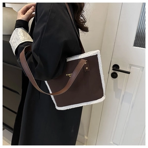 Detail of dark brown leather tote with white plush faux fur trim and gold logo