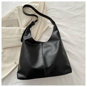 Macro shot of black matte PU leather hobo bag with vertical stitching and adjustable strap