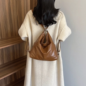 Vintage large caramel brown PU leather tote bag with side pockets shown on a model