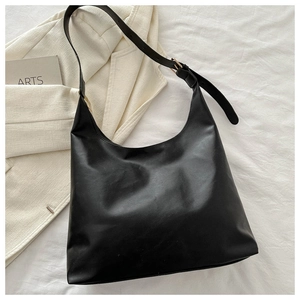 Detail of black matte leather hobo bag with adjustable strap on white fabric