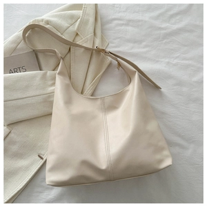 Detail of minimalist cream PU leather tote bag with vertical stitching and wide strap