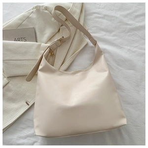 Close-up of cream hobo bag showing matte leather texture and gold hardware accents