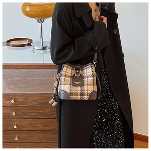 Detail of plaid bucket bag with leather trim and a cute plush rabbit charm