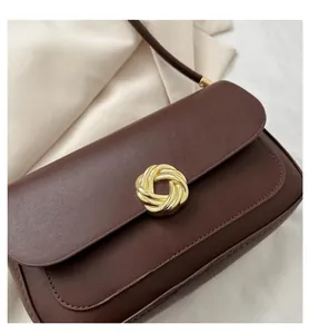 Close-up of retro dark brown leather flap bag featuring a vintage gold woven metal buckle