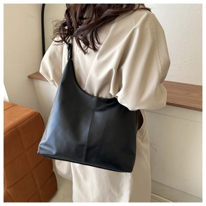 Detail view of black PU leather hobo bag with sleek curved design and vertical stitching