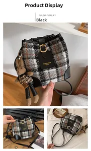 Detail of plaid wool bucket bag with leather accents and cute bunny rabbit charm accessory