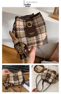 Detail of checkered fabric bucket bag with leather trim and cute rabbit pendant charm