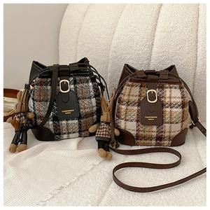 Detail of checkered tweed bucket bags with leather trim and cute bunny charm accessory