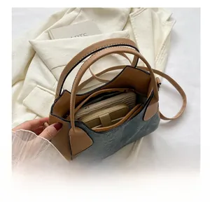 Detailed interior of a two-tone leather shoulder bag showing zipper pocket and spacious capacity