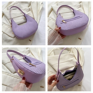 Detail view of purple hobo bag with woven texture, golden zipper and interior storage space