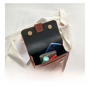 Internal capacity of brown vintage small square bag showing phone and wallet