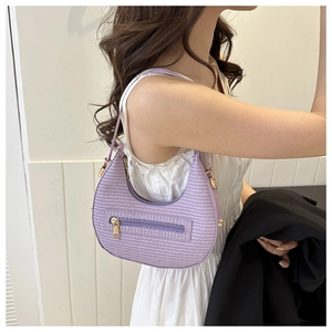 Detail of purple woven hobo bag showing texture, side pocket, and golden hardware
