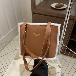 Brown faux leather tote bag with white faux shearling trim in a shopping basket