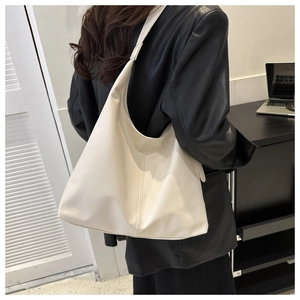 Close-up of the smooth cream leather surface and fine stitching on this large tote bag