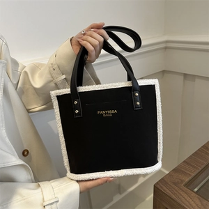 Faux shearling trim tote bag in black and white plush fabric with top leather handles