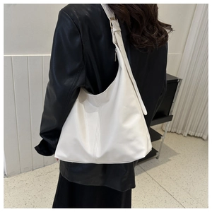 Detail of white large capacity crescent hobo bag shown on shoulder with side view