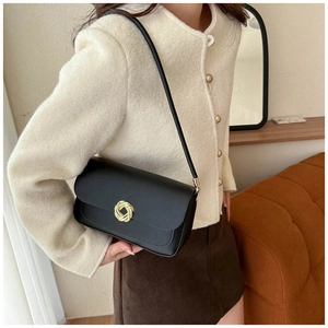 Minimalist black matte leather shoulder bag with vintage gold buckle on model