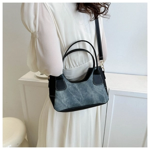 Detail of contrast stitching and blue denim leather texture on women underarm bag