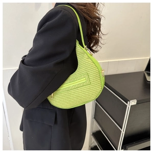 Neon green crocodile texture crescent bag close-up showing woven pattern and gold zipper