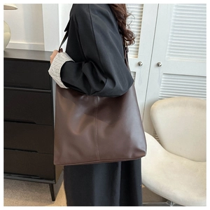 Deep brown oversized PU leather tote bag with vertical stitch detail and wide shoulder strap