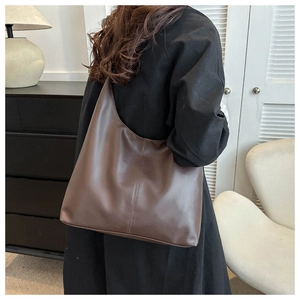 Detail of dark brown hobo bag showing supple leather texture and vertical stitching